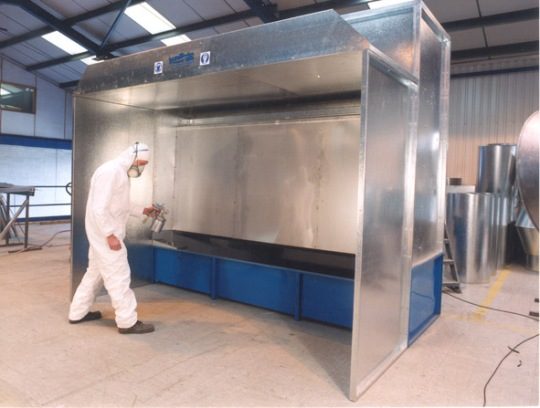 Operator spraying inside a paint spray booth