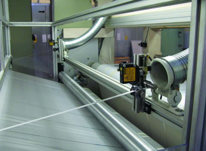 Trim waste being drawn into a suction duct on a printing line